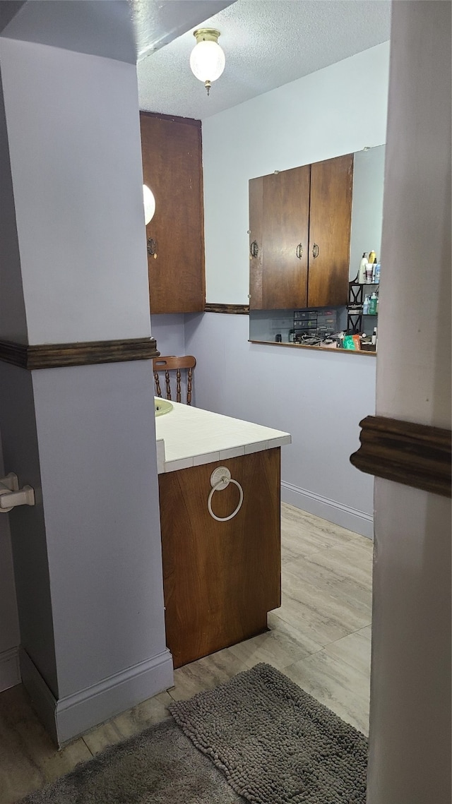 bathroom with a textured ceiling and hardwood / wood-style flooring