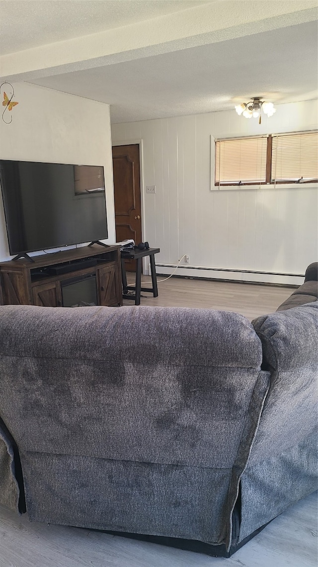 living room with light hardwood / wood-style floors and a baseboard heating unit