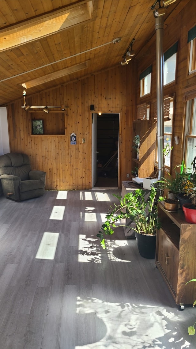 interior space with wood walls, wood-type flooring, wood ceiling, and vaulted ceiling