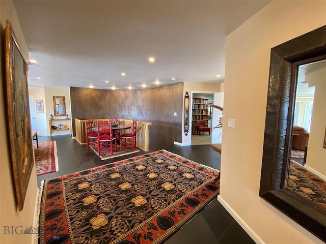 hall with dark tile flooring