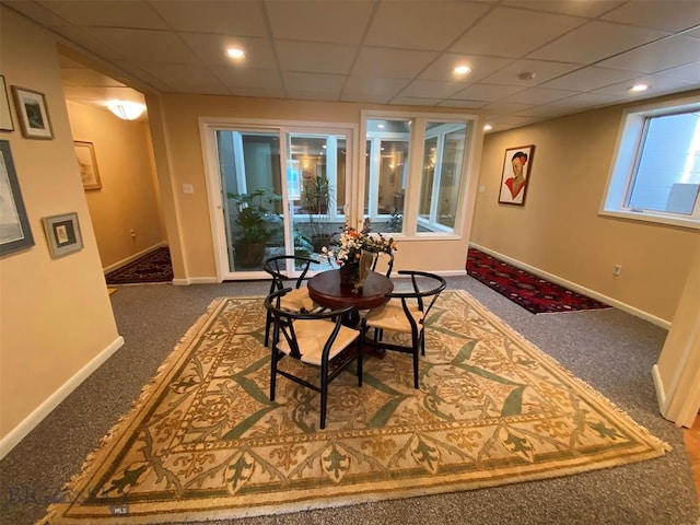 carpeted dining area with a drop ceiling