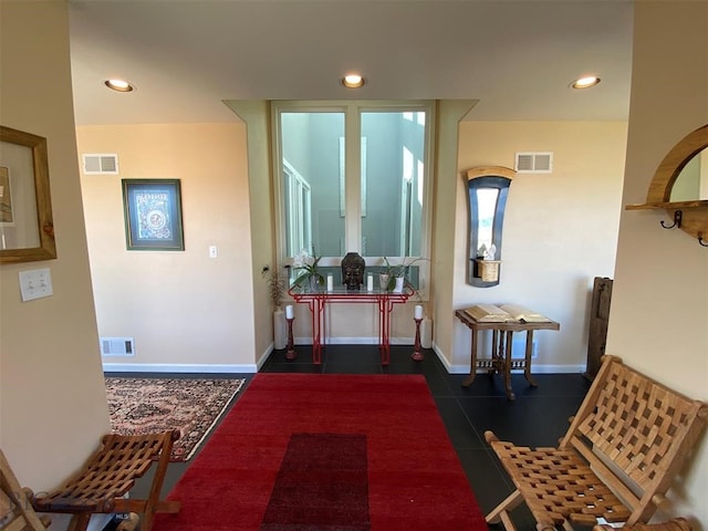 foyer entrance featuring dark tile floors