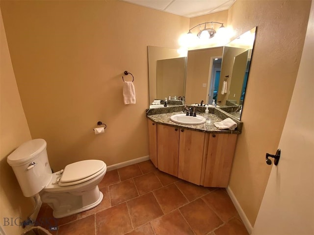 bathroom featuring vanity, toilet, and tile flooring