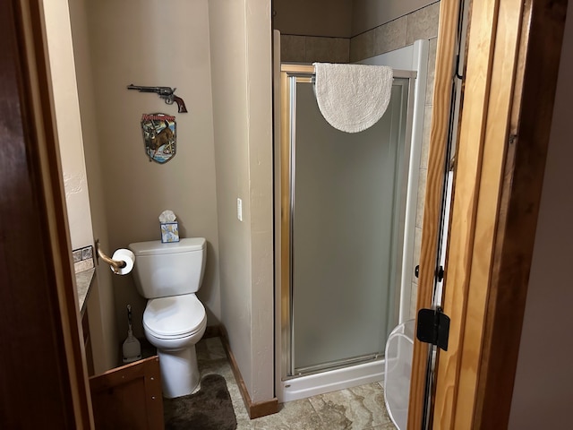 bathroom featuring tile floors, a shower with door, and toilet