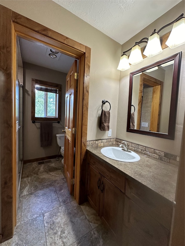 bathroom with tile floors, a textured ceiling, oversized vanity, and toilet