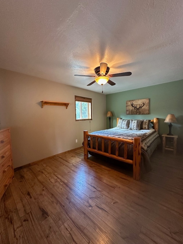 bedroom featuring a textured ceiling, ceiling fan, and hardwood / wood-style floors