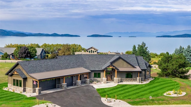 114 Pheasant Ridge Ct, Polson, MT 59860 - craftsman-style home featuring stone siding, a porch, a water and mountain view, asphalt driveway, and a front yard