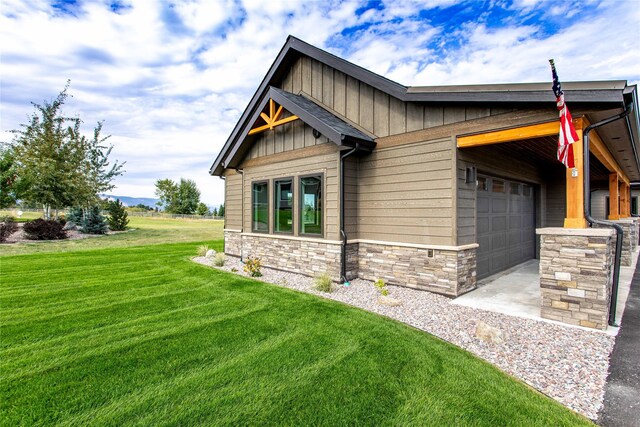 114 Pheasant Ridge Ct, Polson, MT 59860 - view of side of home with board and batten siding, a lawn, stone siding, and an attached garage