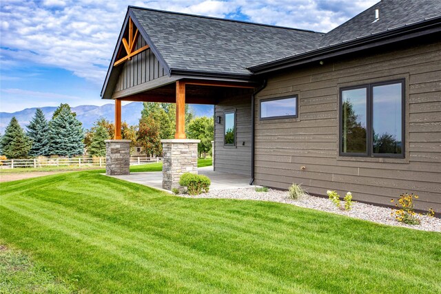 114 Pheasant Ridge Ct, Polson, MT 59860 - view of home's exterior with roof with shingles, a mountain view, and a patio area