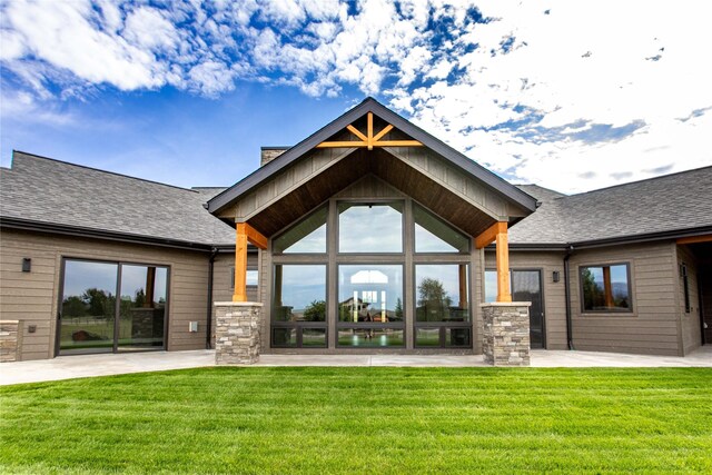 114 Pheasant Ridge Ct, Polson, MT 59860 - rear view of house featuring a yard, stone siding, and roof with shingles