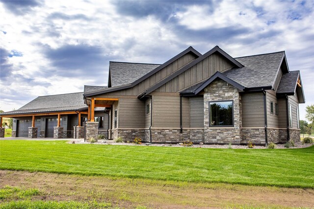 114 Pheasant Ridge Ct, Polson, MT 59860 - craftsman house with stone siding, a front yard, a garage, and board and batten siding