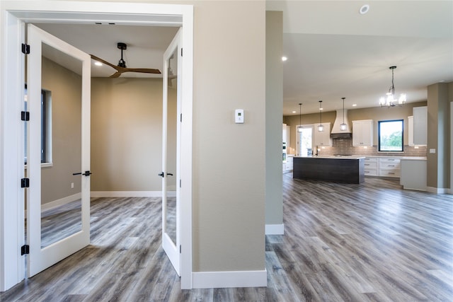 hallway with an inviting chandelier and hardwood / wood-style floors