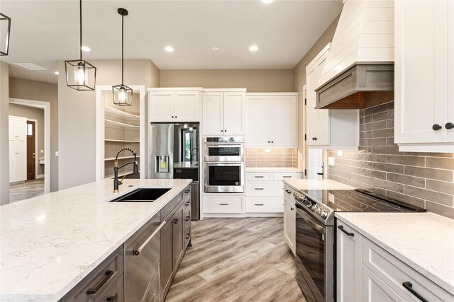 114 Pheasant Ridge Ct, Polson, MT 59860 - kitchen with stainless steel appliances, a sink, custom range hood, light wood-type flooring, and white cabinetry