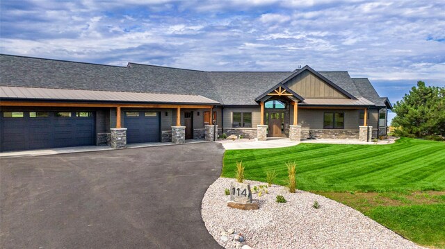 114 Pheasant Ridge Ct, Polson, MT 59860 - craftsman-style house with a garage, asphalt driveway, a front yard, stone siding, and board and batten siding