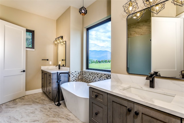 bathroom with a mountain view, vanity, a bathing tub, and a chandelier