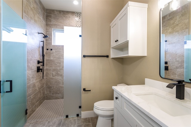 bathroom featuring tile patterned flooring, a shower with shower door, vanity, and toilet