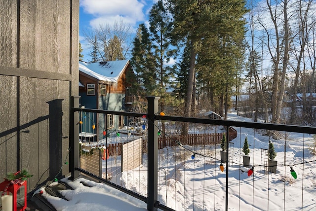 view of snow covered back of property