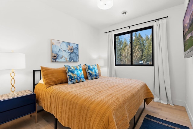 bedroom with light wood-type flooring and baseboards