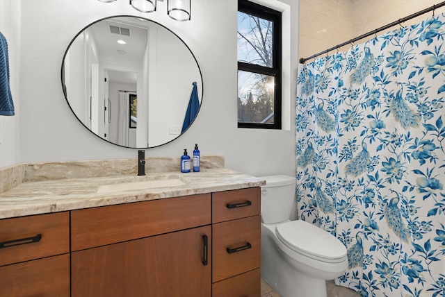 bathroom featuring toilet, curtained shower, visible vents, and vanity