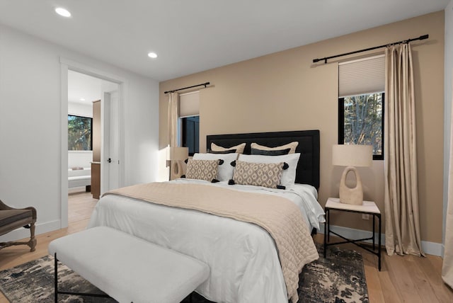 bedroom with recessed lighting, multiple windows, light wood-style flooring, and baseboards