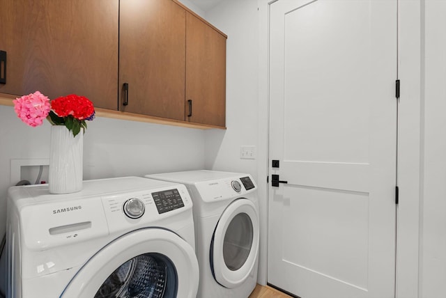 washroom with cabinet space and washer and clothes dryer