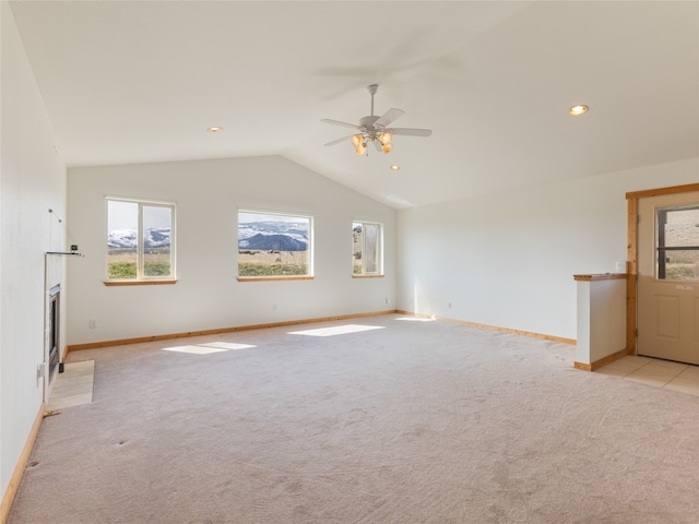 spare room with ceiling fan, lofted ceiling, and light carpet