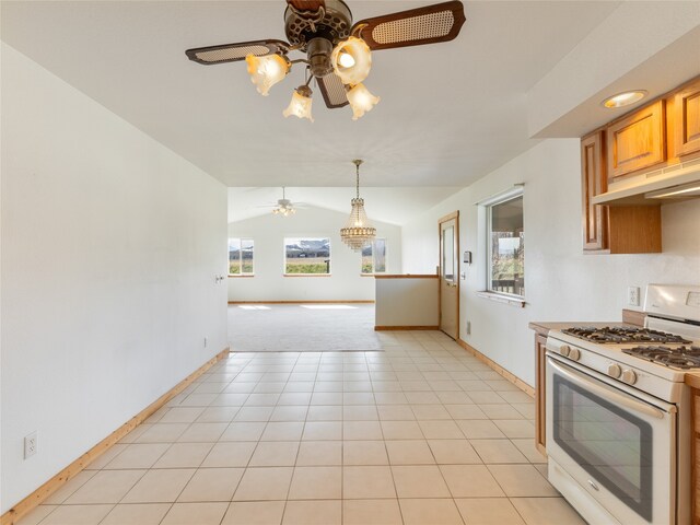 kitchen featuring gas range gas stove, ceiling fan, light tile floors, and a healthy amount of sunlight