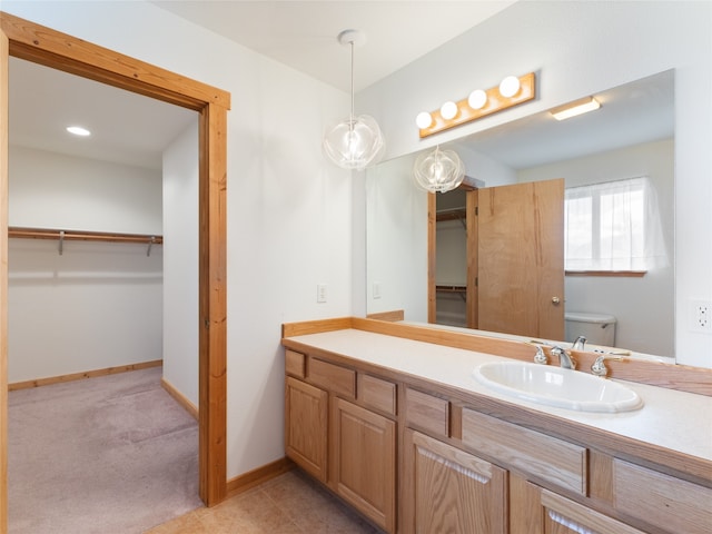 bathroom with tile flooring, toilet, and vanity