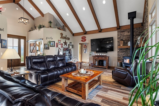 living room with high vaulted ceiling, a wood stove, wood-type flooring, and beam ceiling