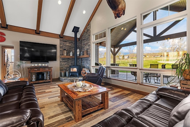 living room featuring a wood stove, beamed ceiling, high vaulted ceiling, and hardwood / wood-style floors