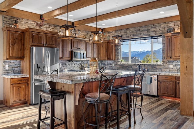 kitchen featuring wood-type flooring, stainless steel appliances, a kitchen island, and a mountain view