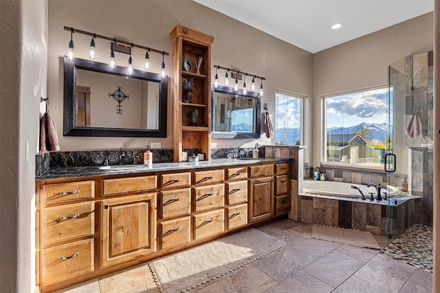 bathroom featuring tile floors, vanity with extensive cabinet space, double sink, and separate shower and tub