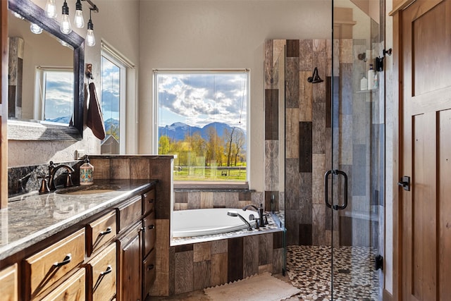 bathroom featuring a mountain view, vanity with extensive cabinet space, and separate shower and tub