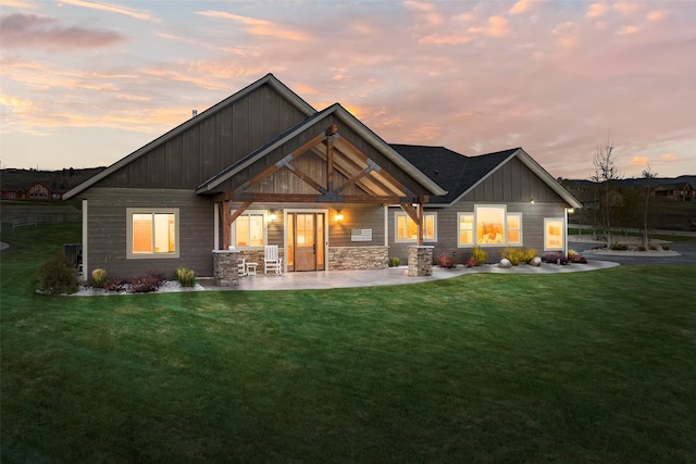 back house at dusk featuring a yard