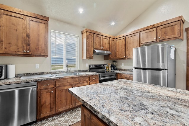 828AND806 Corvallis Hills Dr, Corvallis, MT 59828 - kitchen featuring stainless steel appliances, under cabinet range hood, brown cabinets, vaulted ceiling, and recessed lighting