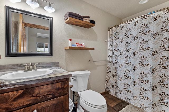 bathroom with hardwood / wood-style flooring, toilet, and vanity