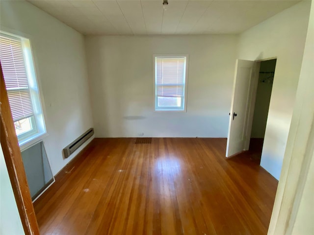 unfurnished room featuring hardwood / wood-style flooring and baseboard heating