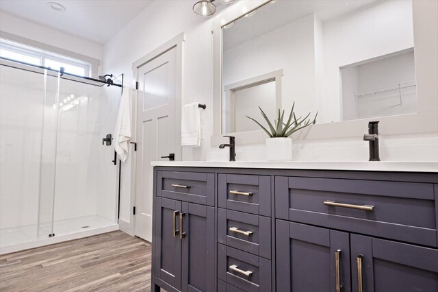 bathroom featuring a shower with shower door, vanity, and hardwood / wood-style flooring