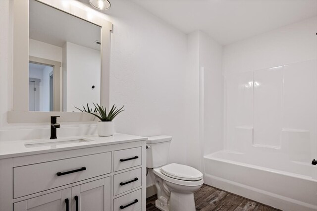 full bathroom featuring vanity, toilet, wood-type flooring, and shower / washtub combination