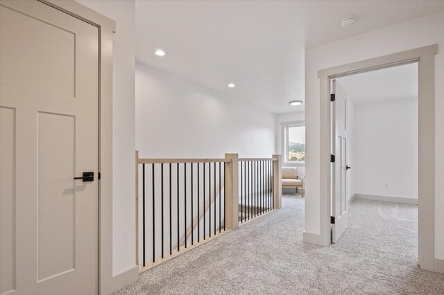 hallway featuring light colored carpet