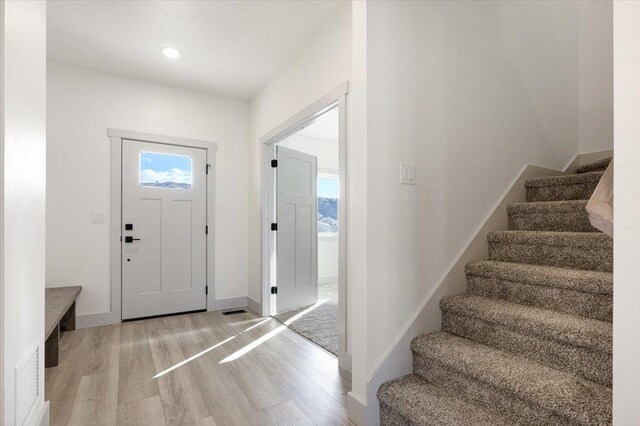 5539 Fireweed Loop, Helena, MT 59602 - kitchen featuring green cabinetry, light wood-style flooring, wall chimney exhaust hood, and appliances with stainless steel finishes