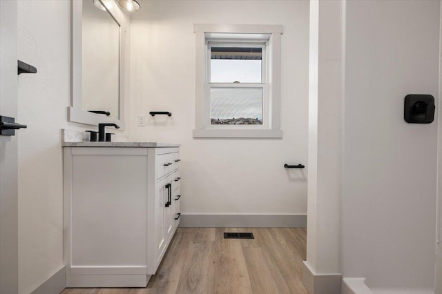 bathroom with hardwood / wood-style flooring and vanity