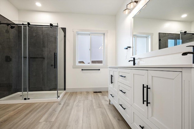 bathroom featuring hardwood / wood-style floors, vanity, and walk in shower