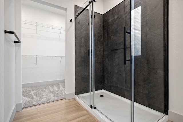 bathroom featuring wood-type flooring and an enclosed shower