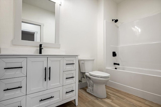 full bathroom with vanity, wood-type flooring, shower / bathtub combination, and toilet