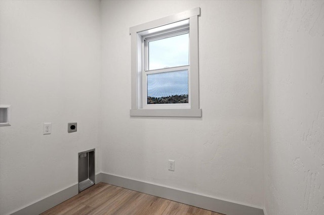 clothes washing area featuring hookup for an electric dryer and light hardwood / wood-style floors