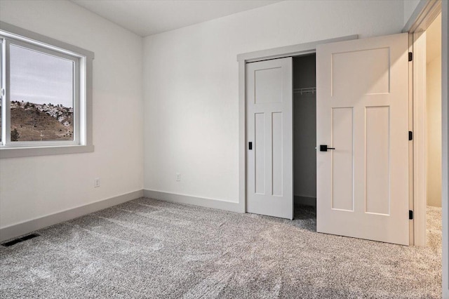 unfurnished bedroom featuring carpet and a closet