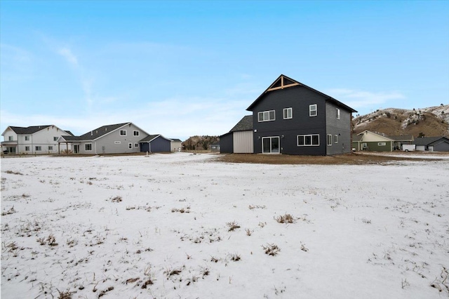 view of snow covered back of property