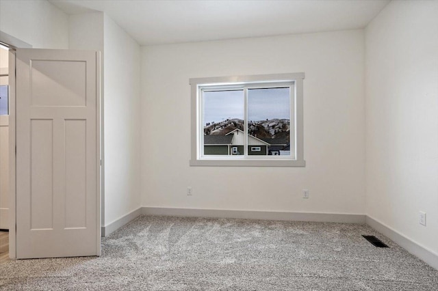 unfurnished room featuring light colored carpet