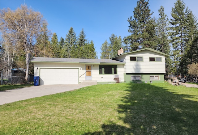 split level home with an attached garage, fence, driveway, a front lawn, and a chimney